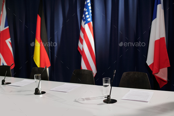 Row of microphones and glasses of water prepared for participants of summit