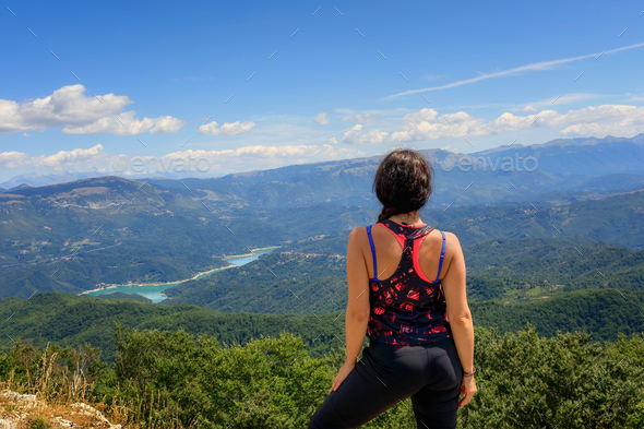 Hiker girl in the mountains scrutinizes the landscape - Stock Photo - Images