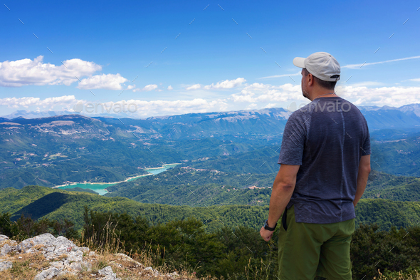 Mountain explorer observes the landscape on the horizon - Stock Photo - Images