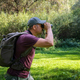 Man explorer in the forest, scanning the horizon with binoculars. - PhotoDune Item for Sale