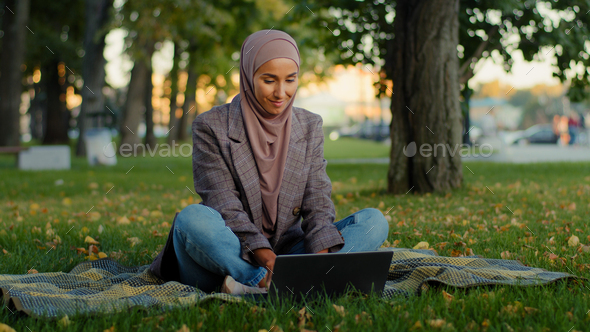 Muslim islamic ethnic student girl in hijab business woman freelancer worker uses laptop sitting on - Stock Photo - Images