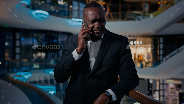Sad ethnic middle-aged man African American entrepreneur answer phone call talking smartphone talk - Stock Photo - Images