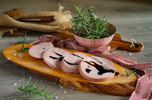 slices of Bologna PGI mortadella on wooden cutting board - Stock Photo - Images