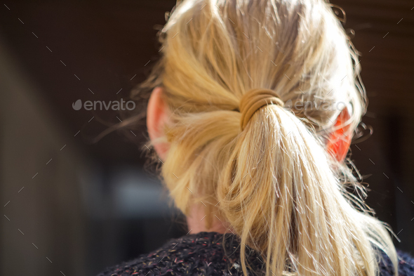 Yellow hair with ponytail. Portrait Of Beautiful Middle Age Blond Woman With Pony Tail. view from th