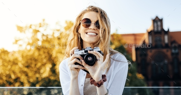 Close up shot of a smiling, fashionably dressed blonde woman posing ...