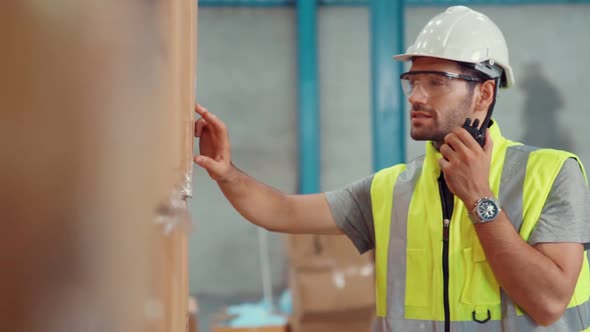 Professional Cargo Worker Talks on Portable Radio to Contact Another Worker alt
