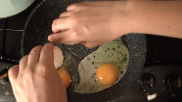 The Egg is Smashed on a Frying Pan on a Dirty Stove with a Whole Yolk