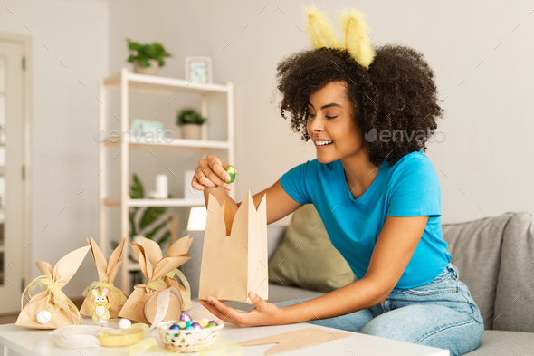 Happy young woman packing bag on bed at home stock photo
