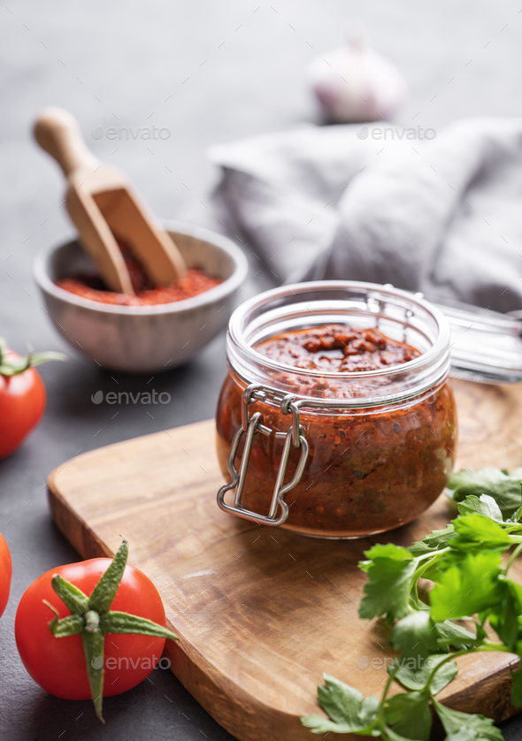 Homemade tomato sauce for pizza or pasta in a jar on a gray background
