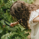 Portrait of a cute little girl looking at plants through a magnifying glass.  - PhotoDune Item for Sale