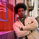 Confident cool young African hipster guy standing at city street near neon sign. - PhotoDune Item for Sale