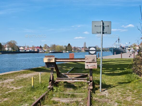 End of a track with a barrier and a river can be seen in the background - Stock Photo - Images