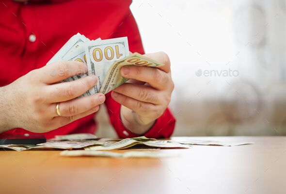 100 dollar bills stacks in hand