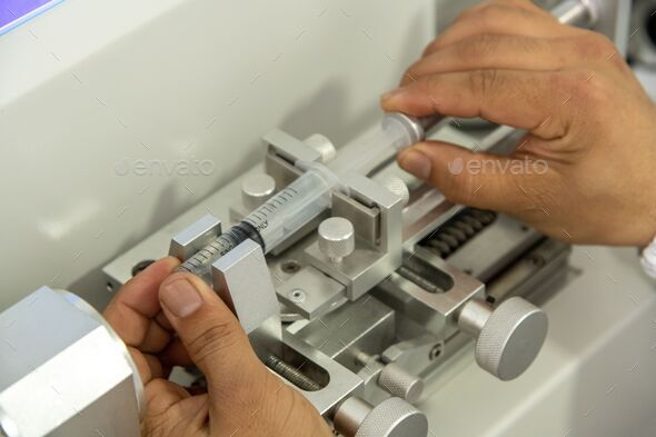 Closeup shot of hands working on a machine in a medical production warehouse for syringes