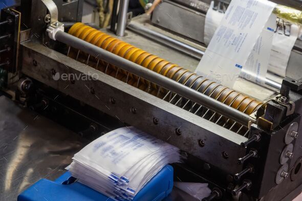 Closeup shot of a machine printing syringe labels at a medical production warehouse