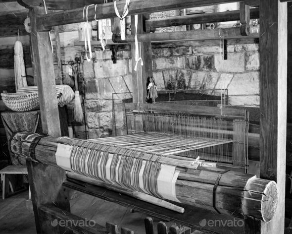 Grayscale shot of a wooden traditional old threads loom machine in a factory