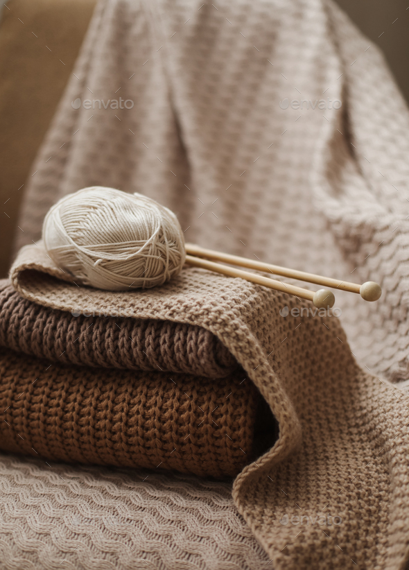 Knitting needles with threads, beige yarn. Hobby for women concept.  Knitting accessories Stock Photo by paralisart