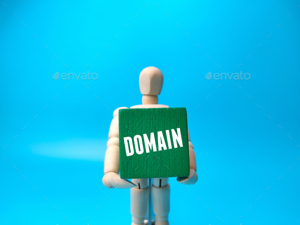 Wooden mannequin holding wooden cube with the word DOMAIN. - Stock Photo - Images