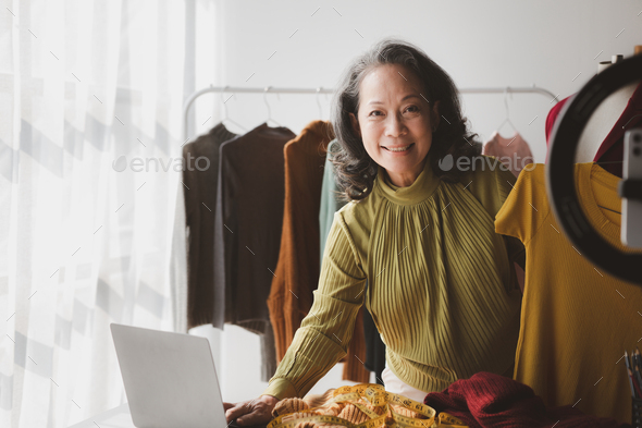 Elderly women are designers who make clothes, she is the owner of a female fashion clothing store an