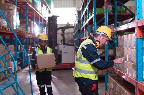 Foreman with employees in warehouse Help each other lift the product ...