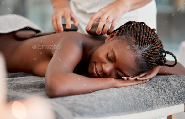 Black woman, hot stone massage and masseuse, hands and zen with holistic therapy and spa treatment.