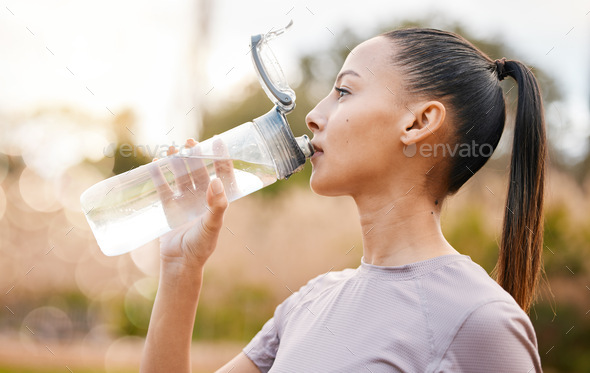 Fitness, health and woman drinking water in nature after exercise, training  or workout. Sports, nut Stock Photo by YuriArcursPeopleimages