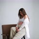 Pregnant Girl Sits on a Chair Against a White Background and Poses for the Camera - VideoHive Item for Sale