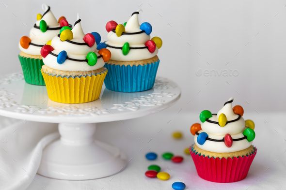 Cakestand with Christmas cupcakes decorated with strings of Christmas lights - Stock Photo - Images