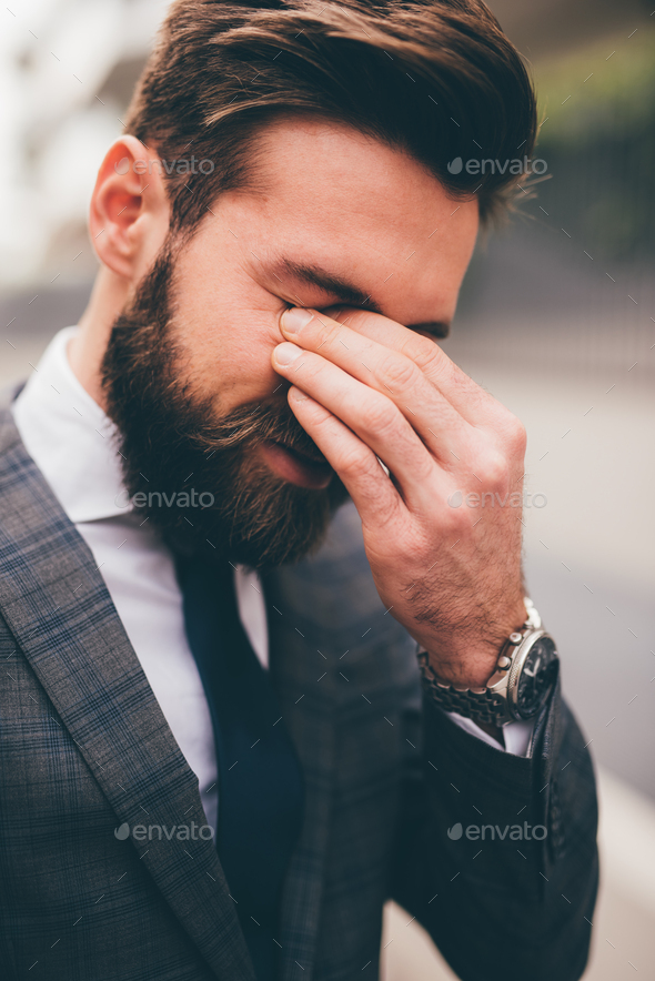 Frustrated and exhausted young bearded businessman - Stock Photo - Images