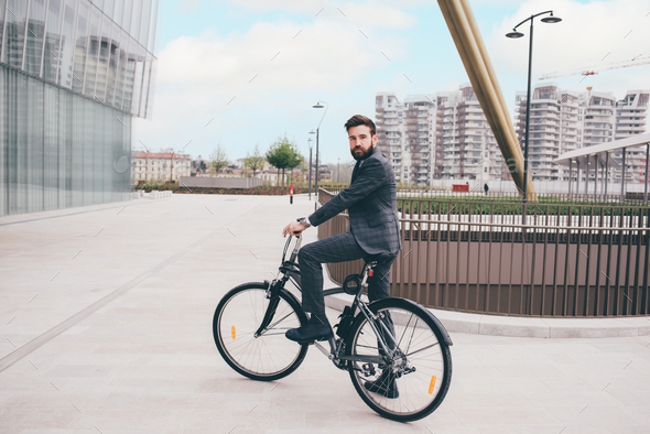 Elegant bearded young stylish businessman going to work by bike - Stock Photo - Images