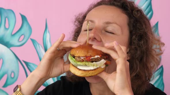 Very Hungry Young Woman Eats Her Vegan Burger with Great Pleasure and Joy alt