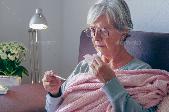 Elderly adult caucasian woman with cough and fever symptoms such as seasonal flu or pollen allergy