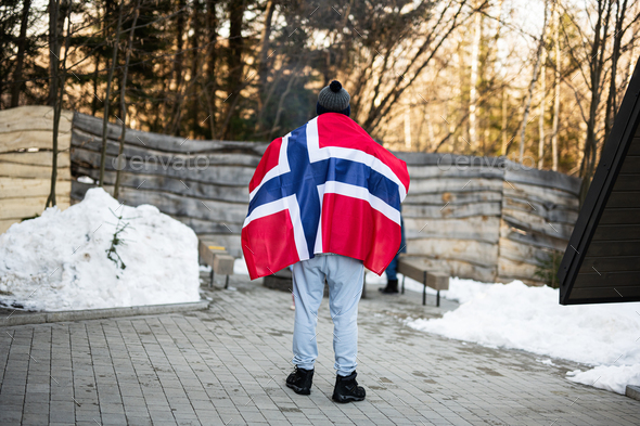 Back of man holding Norway flag. Scandinavian culture, norwegian people.