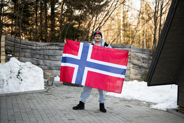 Portrait of man holding Norway flag. Scandinavian culture, norwegian people.