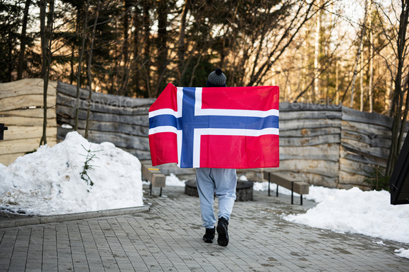 Back of man holding Norway flag. Scandinavian culture, norwegian people.