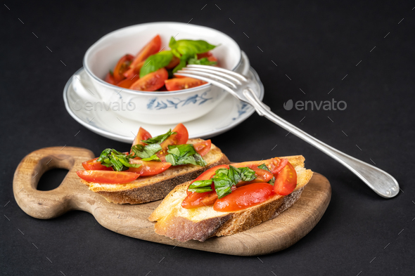 Tasty bruschettas with cherry tomatoes on a wooden board - Stock Photo - Images