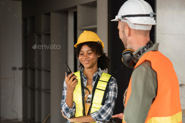 Female male engineers holding walkie talkie radios and inspecting construction site - Stock Photo - Images