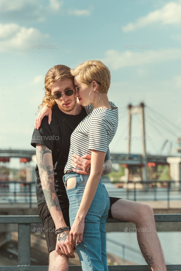 Back View Of Boyfriend With Tattoos And Girlfriend Hugging Near River Stock  Photo, Picture And Royalty Free Image. Image 106072448.