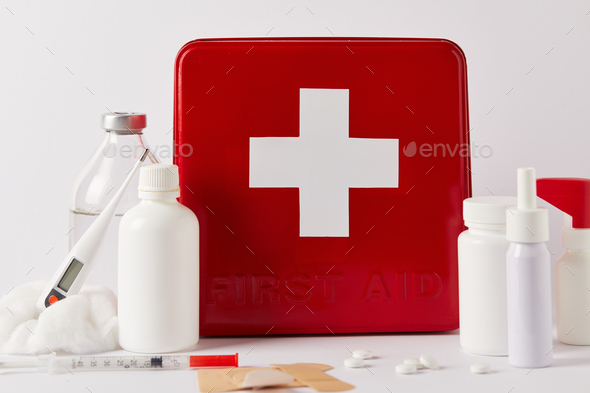 close-up shot of first aid kit box with various medical supplies on white