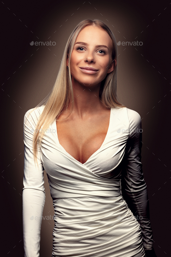 Beautiful fashion portrait of a smiling blonde woman in white dress - Stock Photo - Images