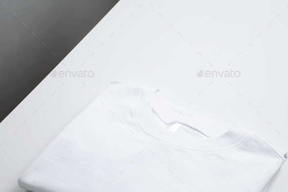 Basic folded white t-shirt. Mock up for branding t-shirt. Copy space