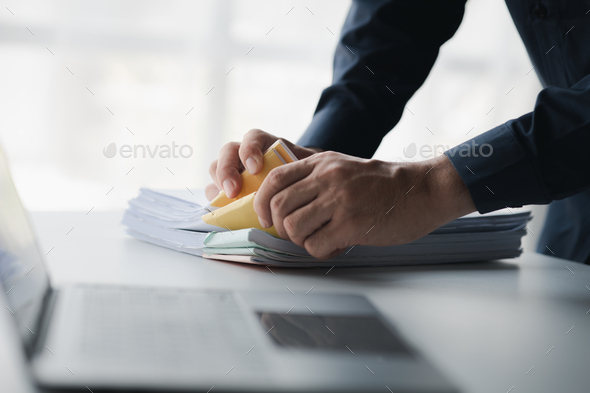 Businessman sorting stacks of department meeting papers, document management in corporate office. Of