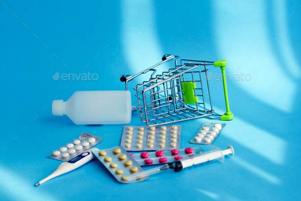 Shopping cart full of medical pills ,thermometer and medicine fell down with medical