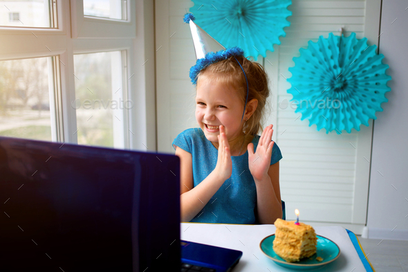 Little happy girl claps her hands, celebrates birthday via the internet
