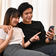 Joyful young couple embracing and shopping online on internet via smart phone. - PhotoDune Item for Sale
