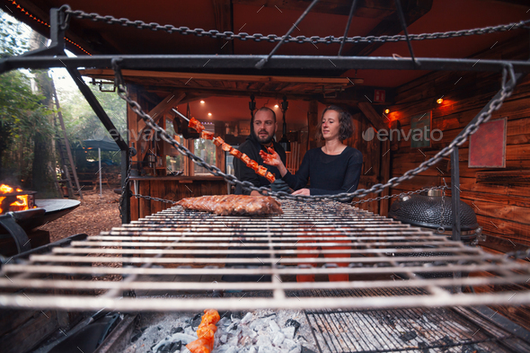 Low-angle view through the barbecue grill of the owners of the steak house