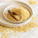 Pile of Dry uncooked bulgur wheat grain with a scoop on a plate close up, copy space. Healthy food - PhotoDune Item for Sale