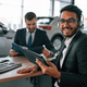Successful deal. Two businessmen are working together in the car showroom - PhotoDune Item for Sale