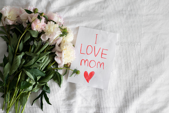 Happy Mothers Day. Fresh peonys and postcard for mom on white background. - Stock Photo - Images