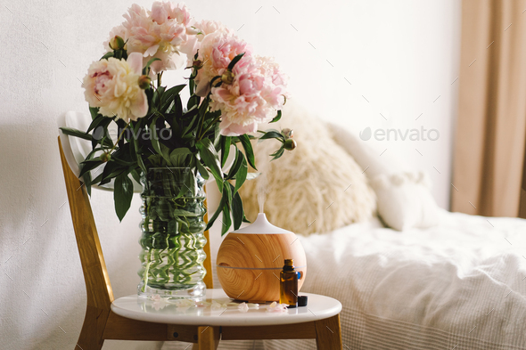 Aroma oil diffuser on chair against in the bedroom. Air freshener. - Stock Photo - Images